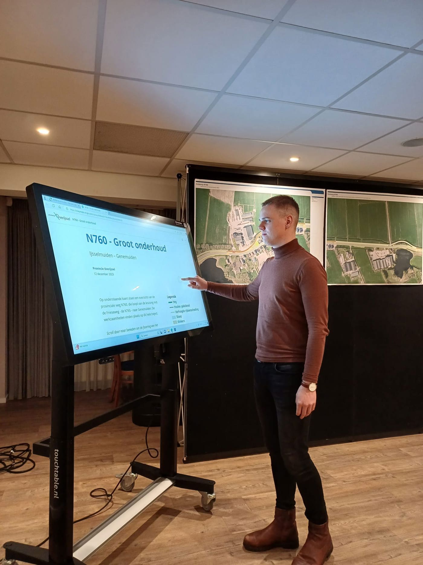 Collega Tiemen staat binnen in een ruimte met een Touchtable, een groot scherm.