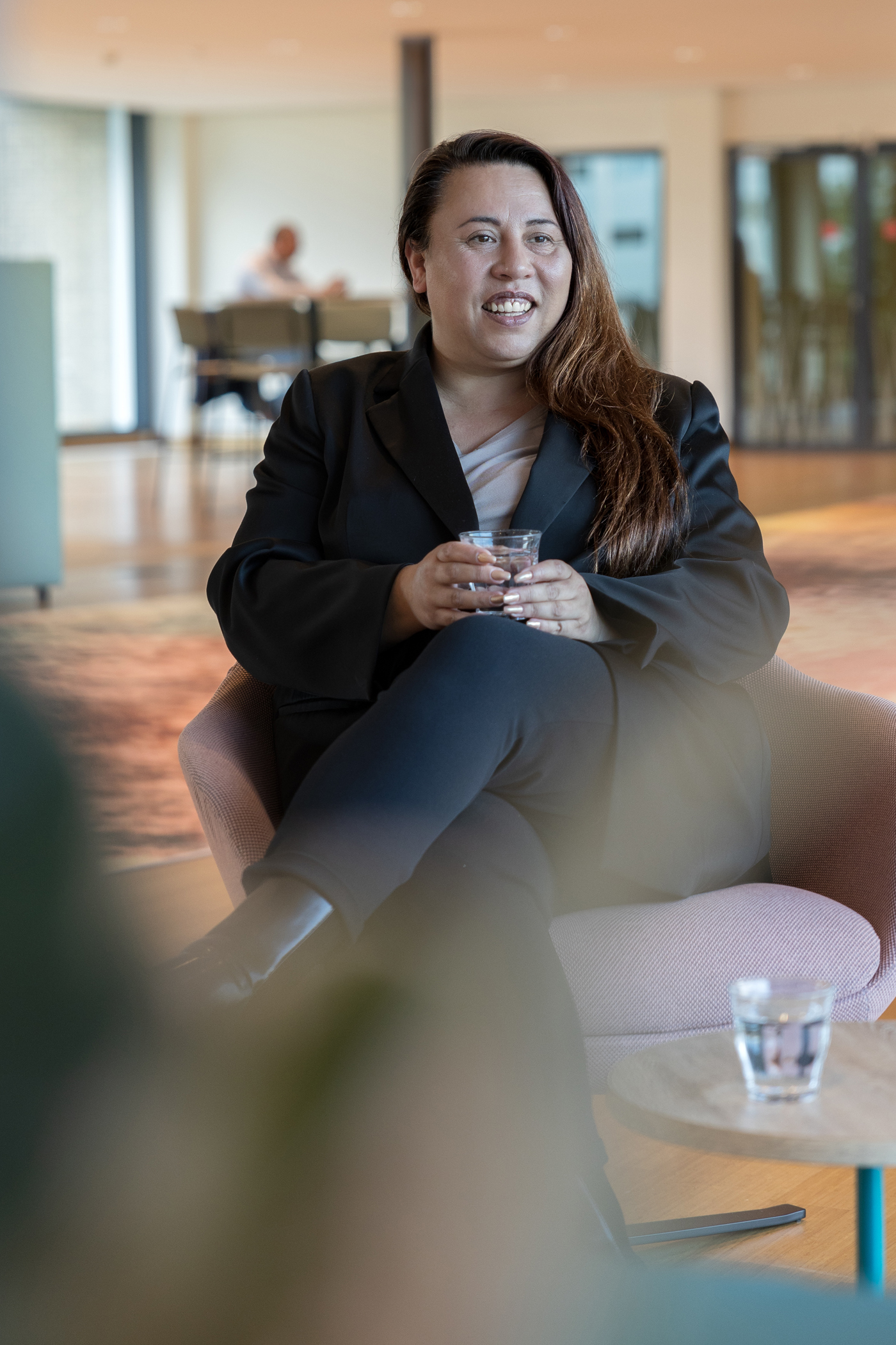 Een portret foto van collega Melanie die op een roze stoel zit in het provinciehuis.