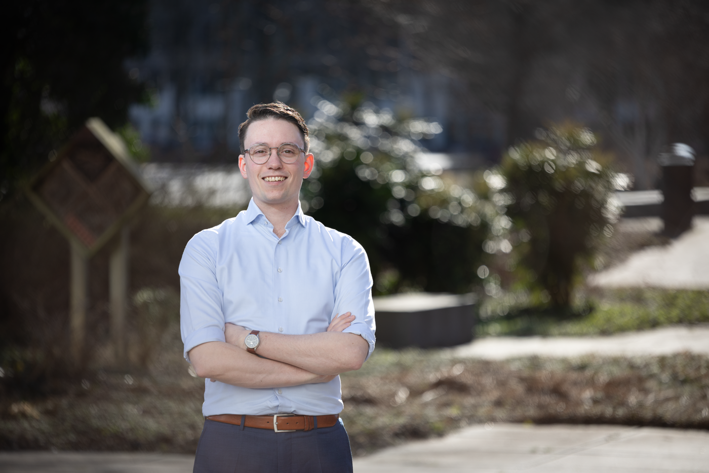 Collega André staat buiten het provinciehuis en kijkt glimlachend naar de camera.