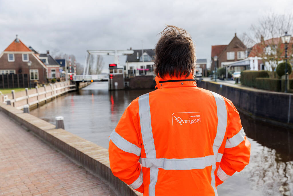 Collega Bart in een oranje hesje bij een kade in Ossenzijl