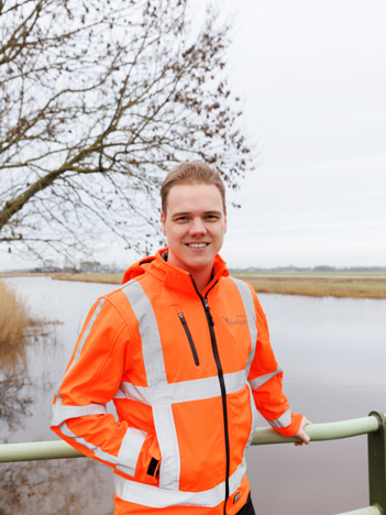 Portretfoto's van collega's Maud en Tiemen. Beide collega's staan voor een reling op een brug bij Genemuiden. Op de achtergrond is water te zien.
