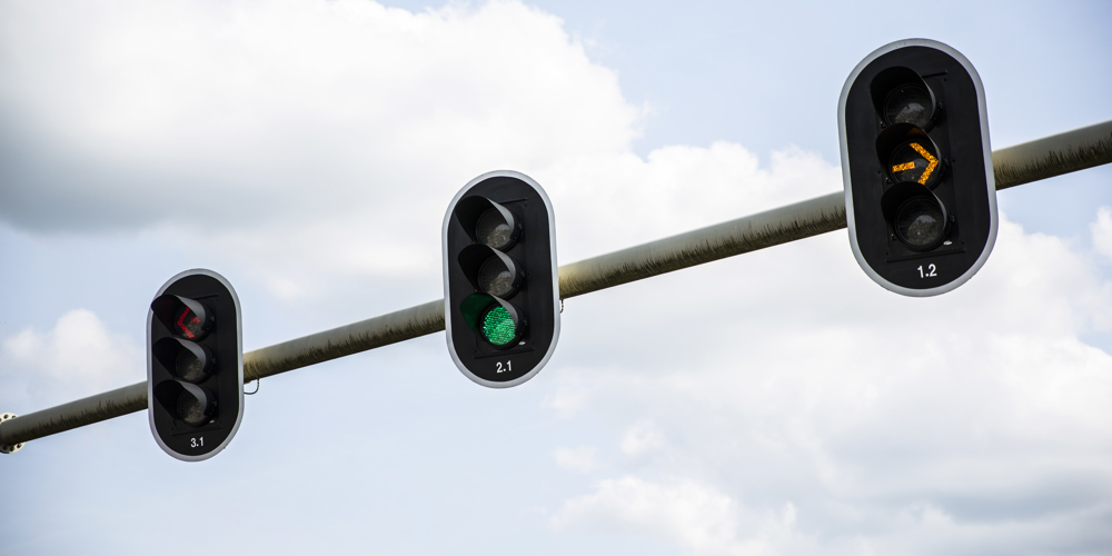 Verkeerslichten zijn te zien met alleen blauwe lucht en wolken op de achtergrond.