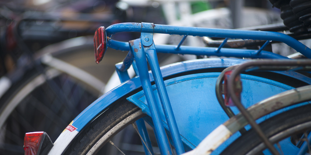 Detailopname van de achterkant van een blauwe fiets.