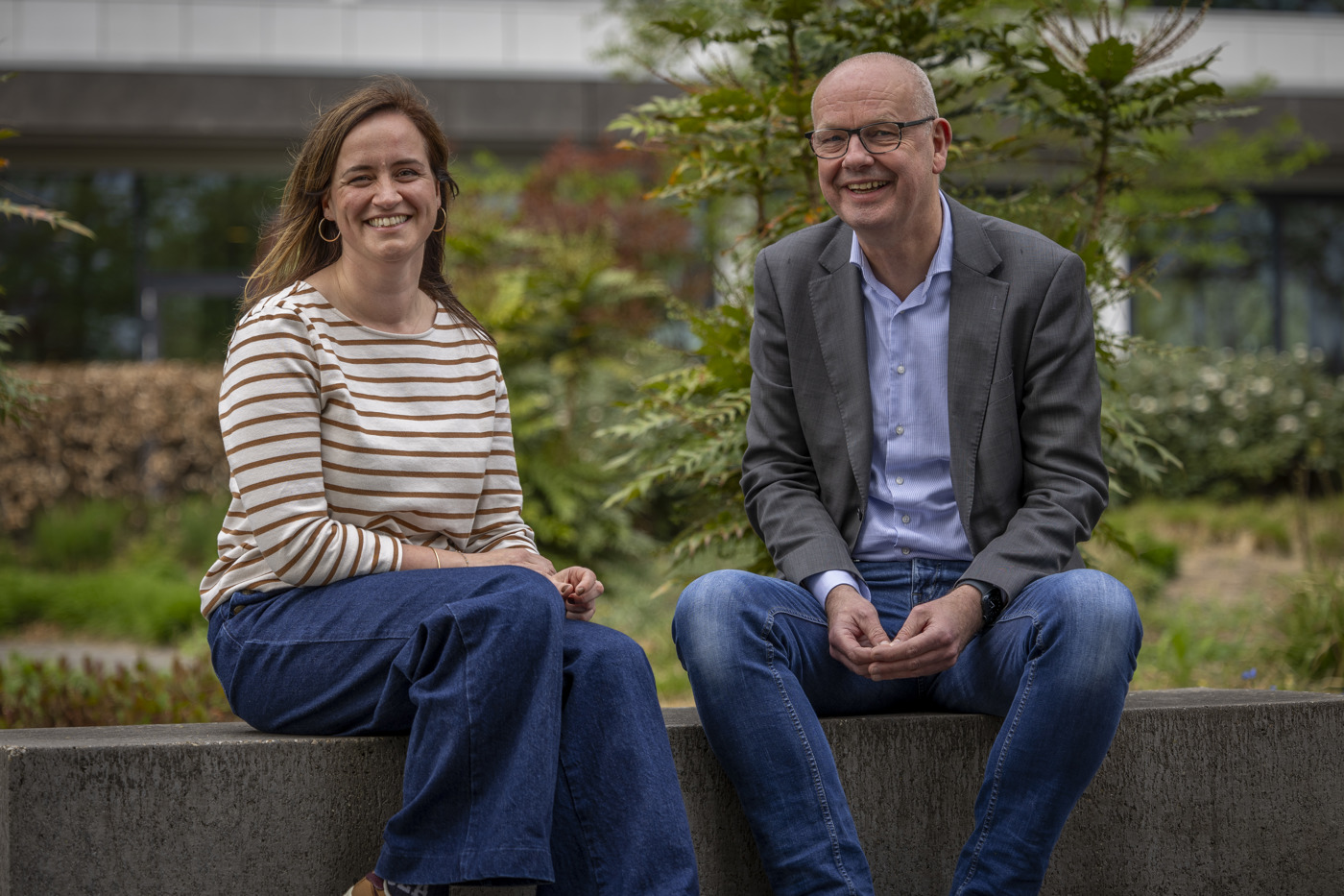 Floor en Sander zitten in de tuin van het provinciehuis op een stenenbank naast elkaar.