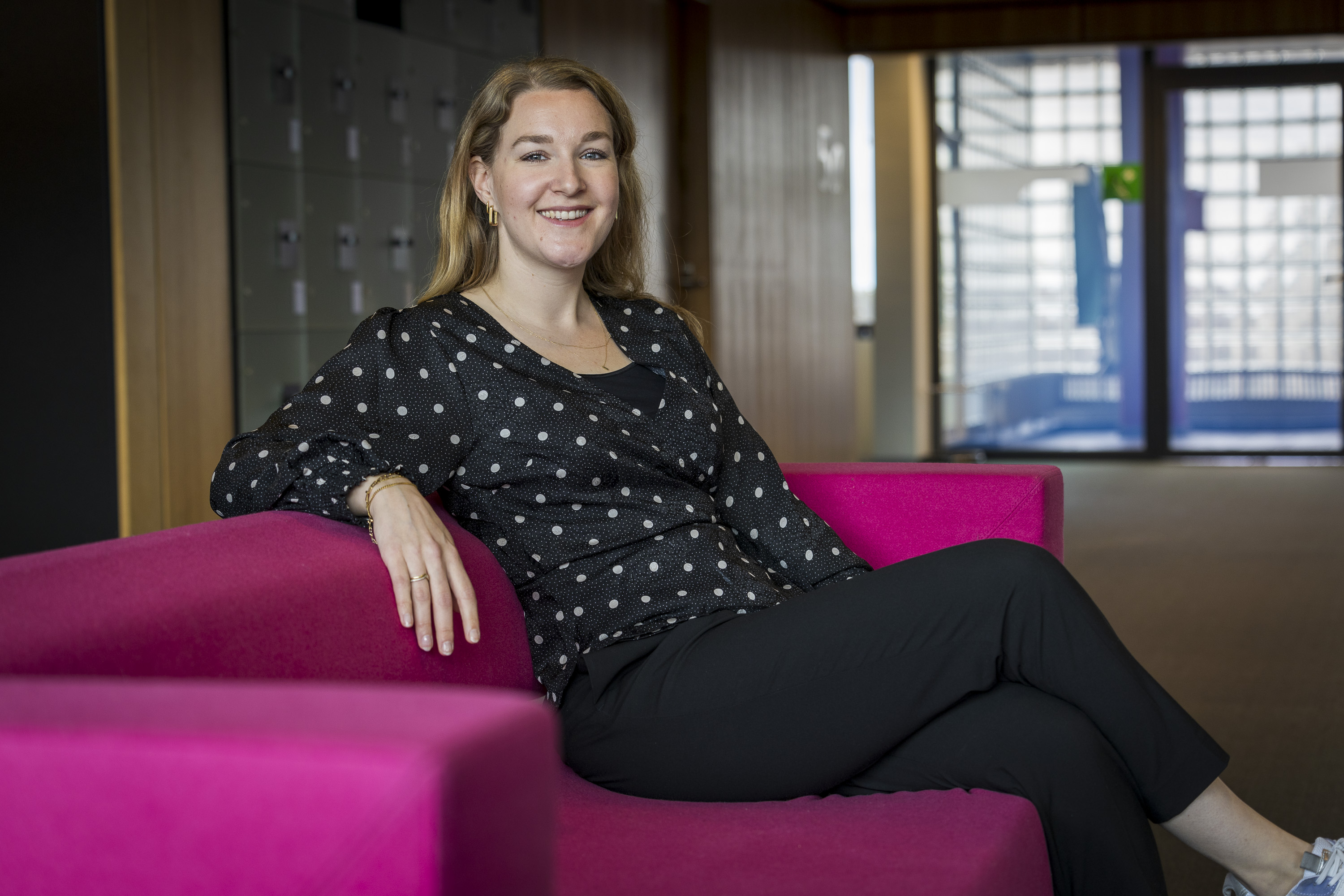 Collega Miriam zit op een roze bank