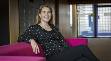 Collega Miriam zit op een roze bank
