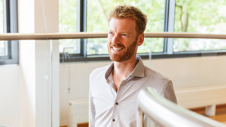 Collega Marc loopt een trap in het provinciehuis op en houdt de leuning vast.