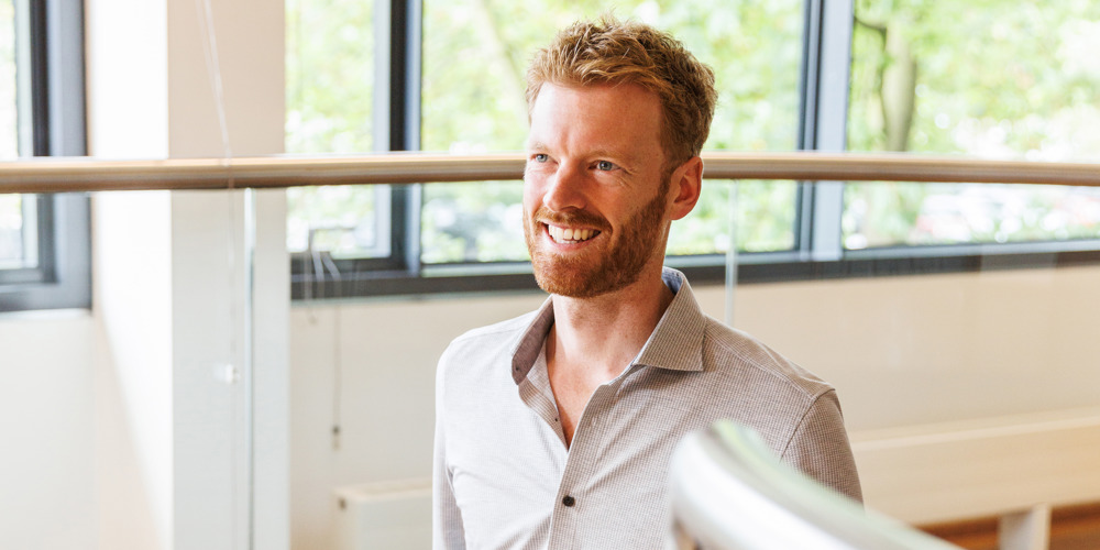 Collega Marc loopt een trap in het provinciehuis op en houdt de leuning vast.